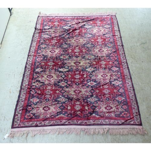 257 - A part silk woven Persian rug, decorated with repeating starburst motifs, on a multi-coloured ground... 