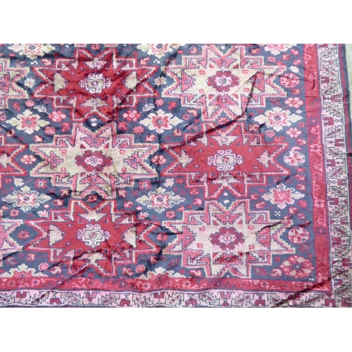 257 - A part silk woven Persian rug, decorated with repeating starburst motifs, on a multi-coloured ground... 