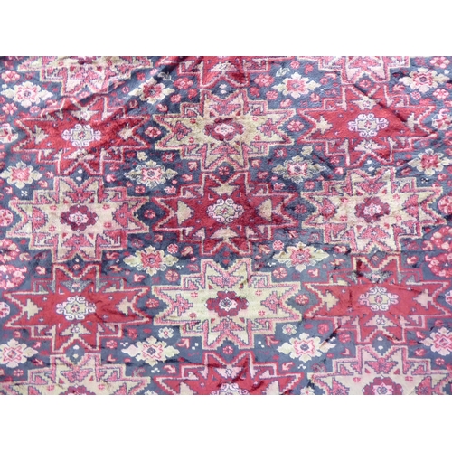 257 - A part silk woven Persian rug, decorated with repeating starburst motifs, on a multi-coloured ground... 