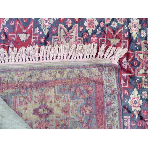 257 - A part silk woven Persian rug, decorated with repeating starburst motifs, on a multi-coloured ground... 