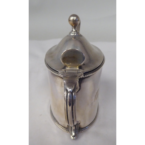 26 - An early 19thC silver oval, bead bordered mustard pot with a hinged, domed lid, thumbpiece, finial a... 