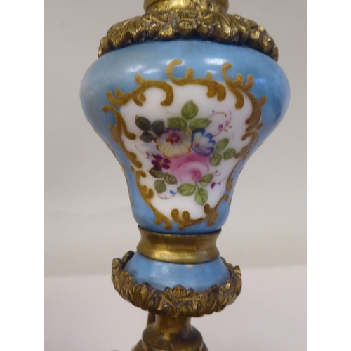 28 - A pair of late 19thC Continental decoratively cast gilt metal and painted porcelain candlesticks wit... 