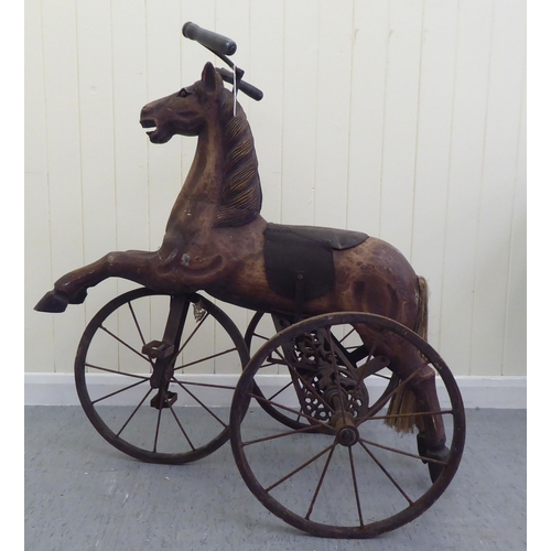 3 - A vintage pedal action, painted wooden toy horse, on three spoked wheels  approx. 30