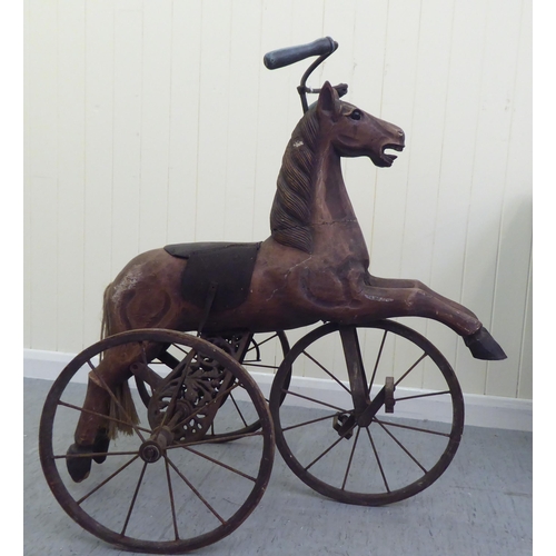 3 - A vintage pedal action, painted wooden toy horse, on three spoked wheels  approx. 30