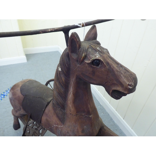 3 - A vintage pedal action, painted wooden toy horse, on three spoked wheels  approx. 30