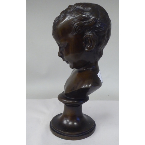 30 - A late 19thC cast and patinated bronze bust, a young boy, on a turned socle  11.5