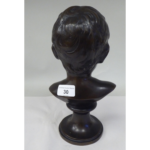 30 - A late 19thC cast and patinated bronze bust, a young boy, on a turned socle  11.5