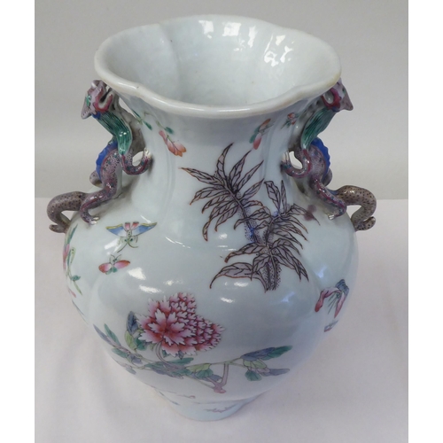 32 - A 20thC Chinese porcelain vase of flattened and panelled baluster form, incorporating opposing, moul... 