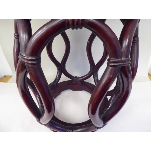 41 - A 20thC Oriental mahogany framed open barrel design stool with simulated bamboo supports