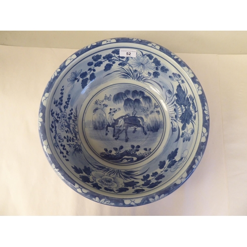 52 - A 19thC Chinese porcelain bowl with a rolled rim, the blue and white ornament featuring playful foal... 