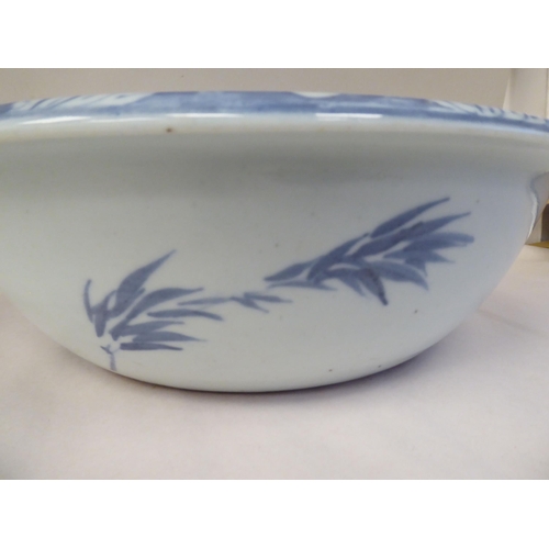 52 - A 19thC Chinese porcelain bowl with a rolled rim, the blue and white ornament featuring playful foal... 