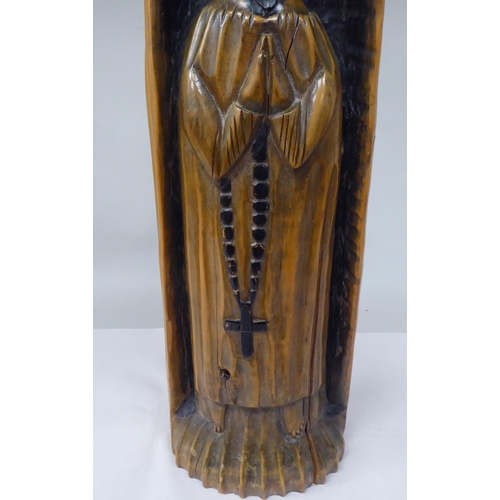 54 - A late 19thC Portuguese carved and stained church ikon, a standing robed figure, in a niche  17