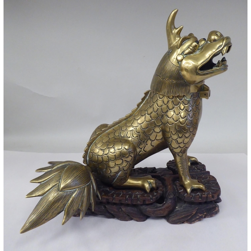 63 - A late 19th/early 20thC Chinese cast bronze censer, fashioned as a seated lion-dog with a hinged hea... 