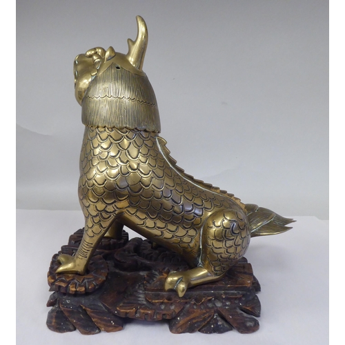 63 - A late 19th/early 20thC Chinese cast bronze censer, fashioned as a seated lion-dog with a hinged hea... 