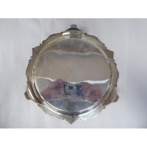 66 - A late Victorian silver salver with a raised, C-scrolled and shell cast border and conforming surfac... 