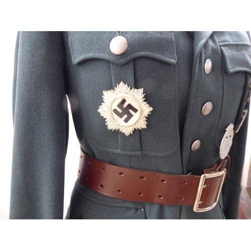 67 - A German World War II design military tunic with emblems and a peaked cap(Please Note: this lot is s... 