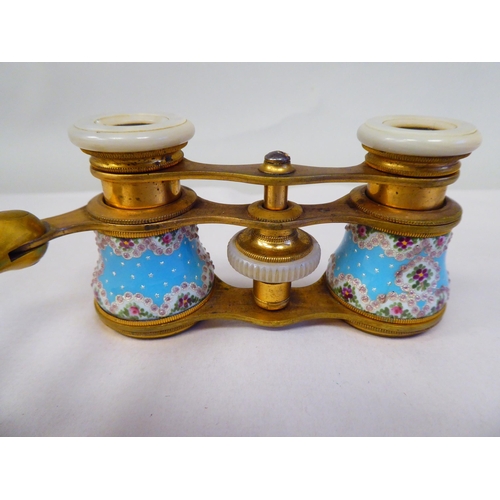 69 - A pair of late 19thC gilt metal and enamelled opera glasses with decoratively painted and inland orn... 