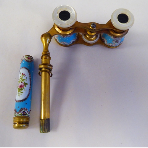 69 - A pair of late 19thC gilt metal and enamelled opera glasses with decoratively painted and inland orn... 