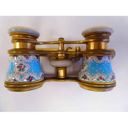 69 - A pair of late 19thC gilt metal and enamelled opera glasses with decoratively painted and inland orn... 