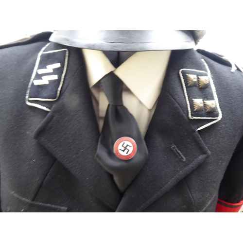 71 - A German World War II design SS military tunic with emblems and a peaked cap(Please Note: this lot i... 