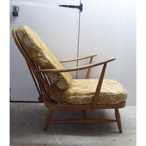 78 - A pair of Ercol blonde elm and beech framed high hoop and spindled back chairs with open arms and lo... 