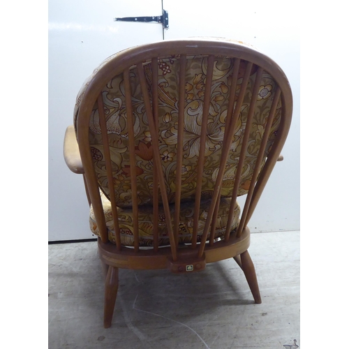 78 - A pair of Ercol blonde elm and beech framed high hoop and spindled back chairs with open arms and lo... 