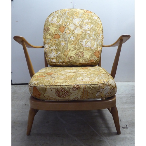 78 - A pair of Ercol blonde elm and beech framed high hoop and spindled back chairs with open arms and lo... 