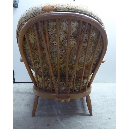 78 - A pair of Ercol blonde elm and beech framed high hoop and spindled back chairs with open arms and lo... 