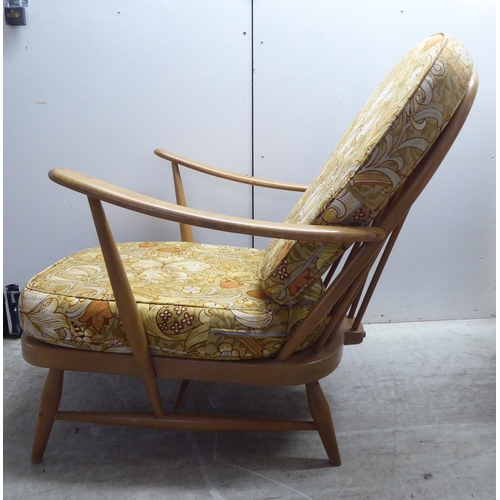 78 - A pair of Ercol blonde elm and beech framed high hoop and spindled back chairs with open arms and lo... 