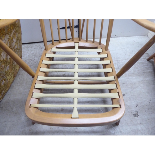 78 - A pair of Ercol blonde elm and beech framed high hoop and spindled back chairs with open arms and lo... 