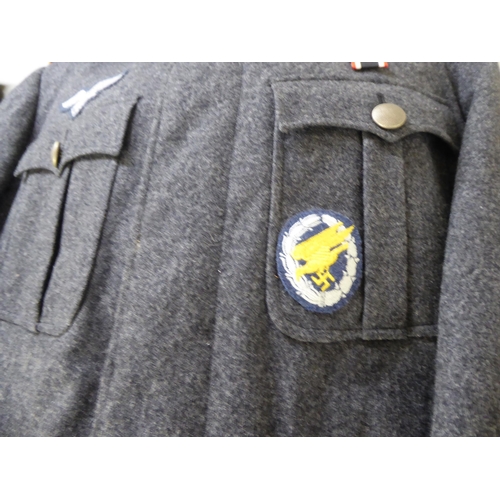 96 - Two dissimilar German World War II style military tunics with emblems(Please Note: this lot is subje... 