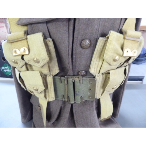 97 - A British Army tunic with webbing belts; and a peaked cap(Please Note: this lot is subject to the st... 