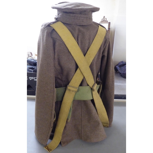 97 - A British Army tunic with webbing belts; and a peaked cap(Please Note: this lot is subject to the st... 