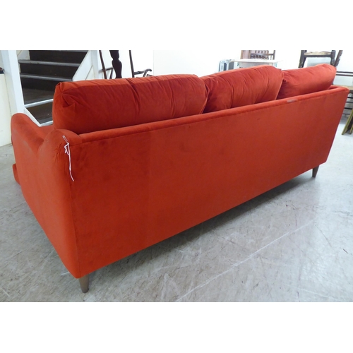 245 - A modern three person settee, upholstered in bright red fabric, raised on pegged feet  82