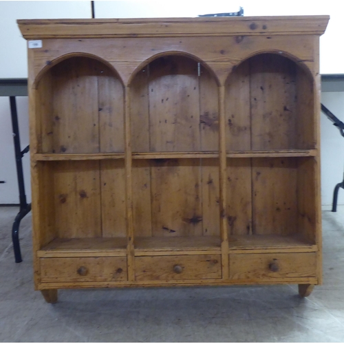 199 - An early 20thC rustically constructed pine hanging unit with two open shelves, over a trio of inline... 