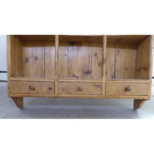 199 - An early 20thC rustically constructed pine hanging unit with two open shelves, over a trio of inline... 