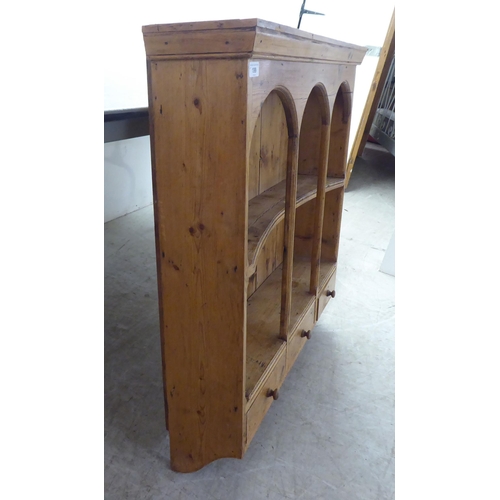 199 - An early 20thC rustically constructed pine hanging unit with two open shelves, over a trio of inline... 