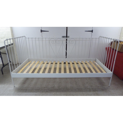 207 - A 20thC white painted tubular and C-scrolled metal framed three side open day bed  77