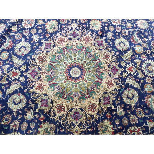 259 - A Persian carpet, decorated with floral and foliate designs, on a mainly dark blue and multi-coloure... 