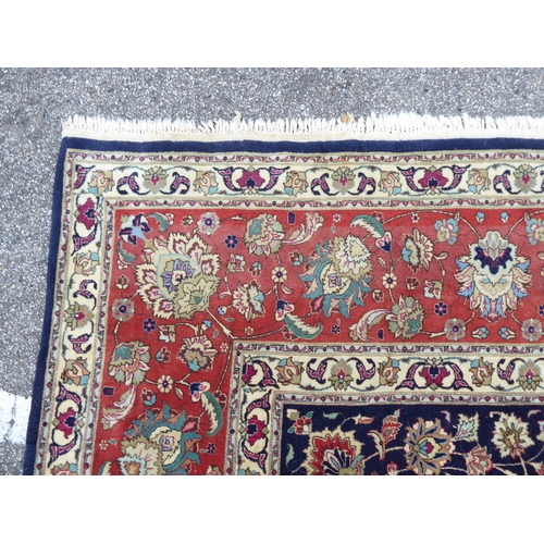 259 - A Persian carpet, decorated with floral and foliate designs, on a mainly dark blue and multi-coloure... 