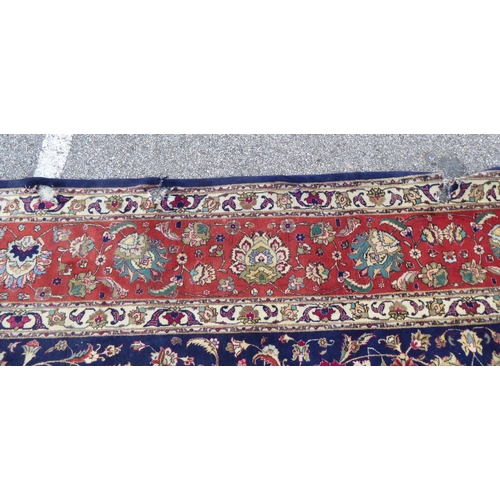 259 - A Persian carpet, decorated with floral and foliate designs, on a mainly dark blue and multi-coloure... 