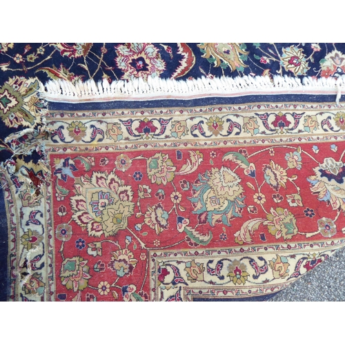 259 - A Persian carpet, decorated with floral and foliate designs, on a mainly dark blue and multi-coloure... 