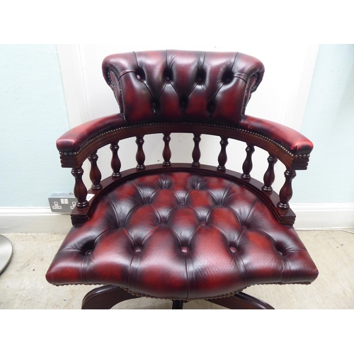 264 - A modern Captains style mahogany showwood framed desk chair, stud and part button upholstered in ox ... 