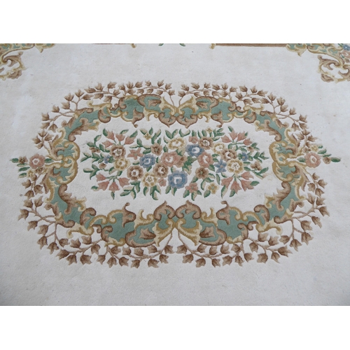 266 - An Indian Kayan wash woollen carpet with a central motif bordered by additional floral and C-scroll ... 