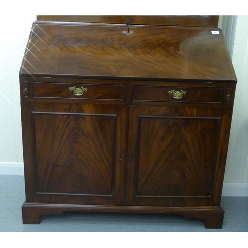 282 - A George III mahogany bureau bookcase with two astragal glazed doors, the fall flap over a drawer an... 