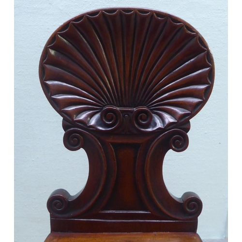 285 - A William IV/Regency mahogany shell and C-scroll carved hall chair, the solid seat raised on reeded,... 