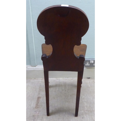 285 - A William IV/Regency mahogany shell and C-scroll carved hall chair, the solid seat raised on reeded,... 