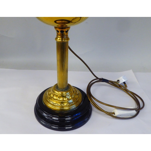 298 - An early 20thC lacquered brass oil lamp (later converted to electricity) with a part-frosted glass b... 