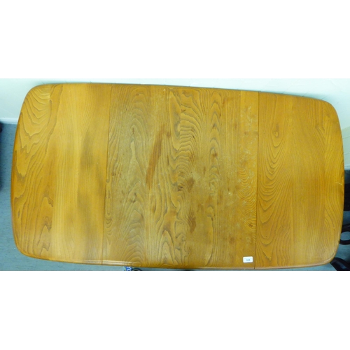 308 - A blonde Ercol elm dining table, raised on square, tapered legs  30