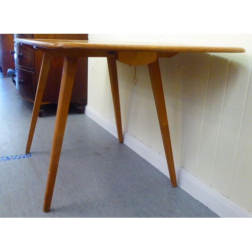 308 - A blonde Ercol elm dining table, raised on square, tapered legs  30